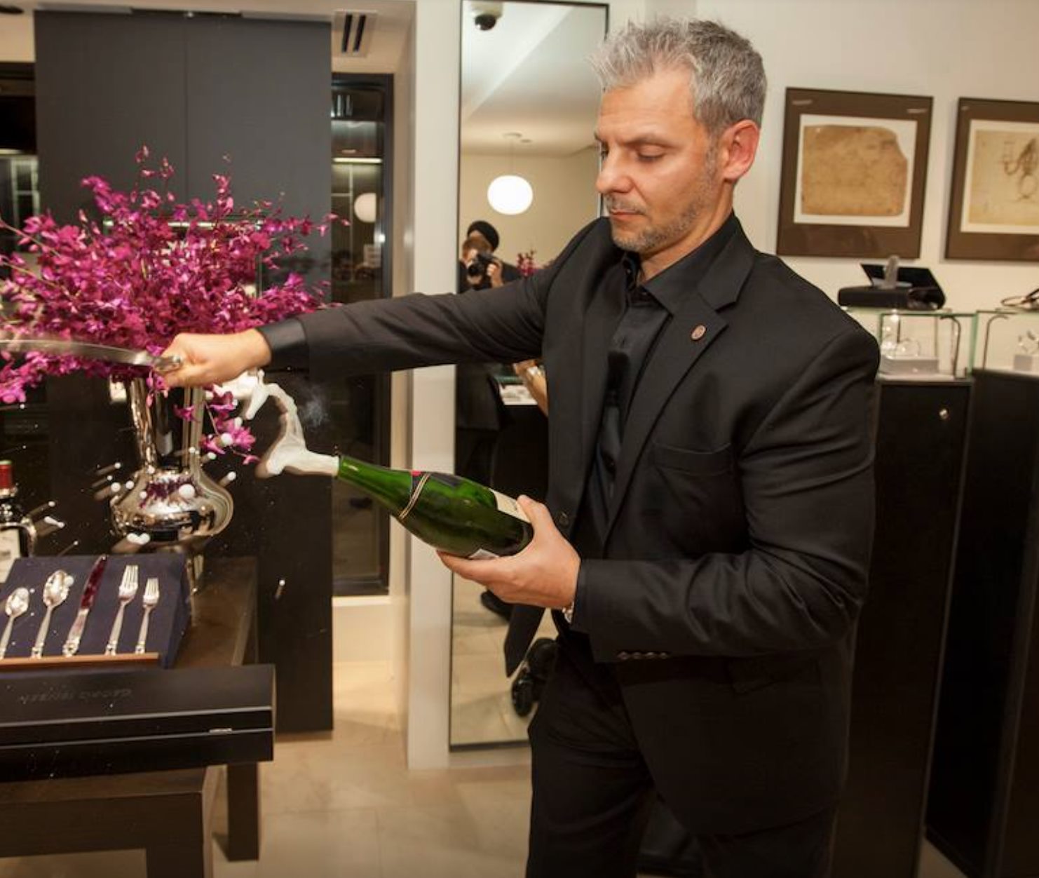 Michael Bottigliero sabering a bottle of champagne at a Bottles Nation tasting event